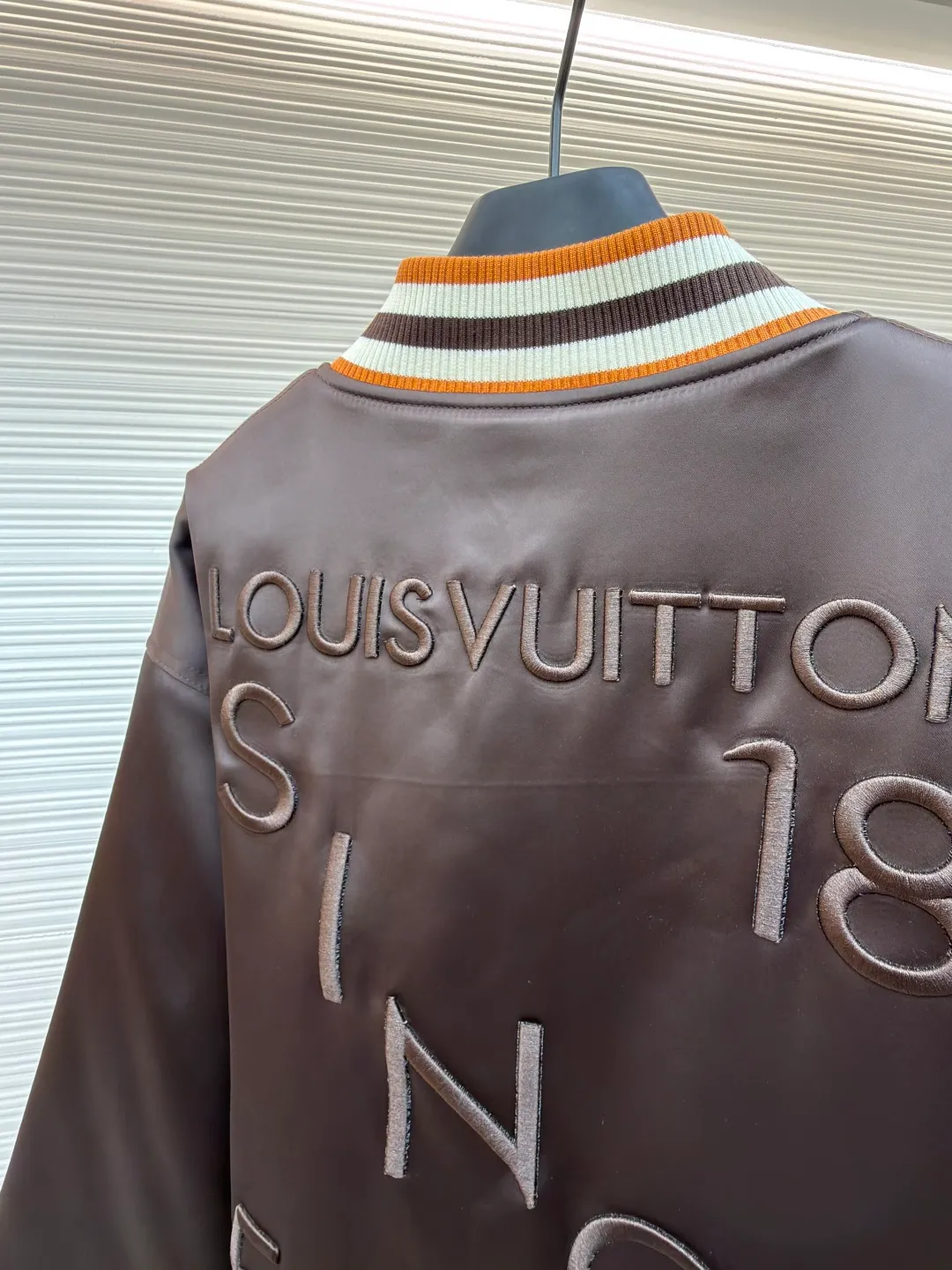 LOUIS VUITTON decorative flight jacket ●Original version: 30,000 purchased and developed ●Item number: 1682285-B90 ●Fabric: cotton fabric ●Technology: patch production ●Color: brown ●Version: fitted version ●Weight: about 1085 grams ●Size: 46-48-50-52 ●Description: The main body of this Louis Vuitton satin baseball jacket is made of high-density matte satin fabric, which has been treated with anti-wrinkle shaping technology. The fabric has a strong drape and is not easy to wrinkle. The dark brown background color is prepared by precision dyeing and finishing technology, giving it a rich color and high-end texture. The "L.V.M SINCE 1854" logo on the left chest is made with hot-drilling technology. High-quality rhinestones are used for precise hot-pasting in different areas. The diamond surface is shiny and strong and will not fall off easily. The ribbed splicing of the collar, cuffs and hem is a three-color contrasting design. It is woven with high-elastic knitted yarn, which will not easily loosen and deform after long-term wear. The placket is equipped with custom-made metal snaps. The hardware is thick and anti-oxidation. The overall style is loose and off-shoulder. The splicing is covered with blind stitching technology, and the wiring is smooth and traceless. Every craft detail follows the brand's luxury product production standards, taking into account both design and wearing comfort. The overall wiring is straight and delicate, the fabric is comfortable and soft, and the color is consistent without color difference. It can be matched with the same style to create a fashionable look and control various occasions. Customized accessories, complete with three standards, same style for men and women!